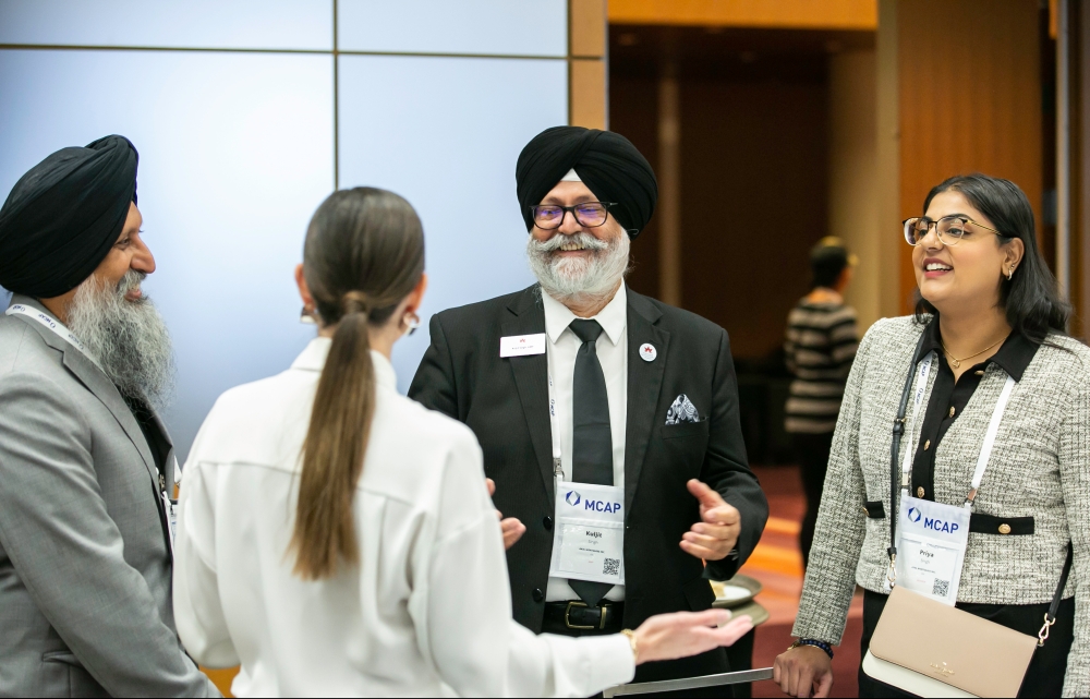 Four people talking to each other at a conference